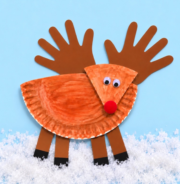 Easy DIY Paper Reindeer Craft For Kids. A simple and fun Christmas craft using handprints for the antlers. Great for preschool age kids to make at home or in the classroom.
