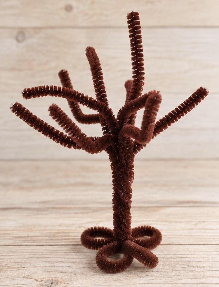 Brown pipe cleaner tree trunk with branches, made for lacing beads onto. A fun and easy to set up fine motor activity for toddlers and preschoolers.