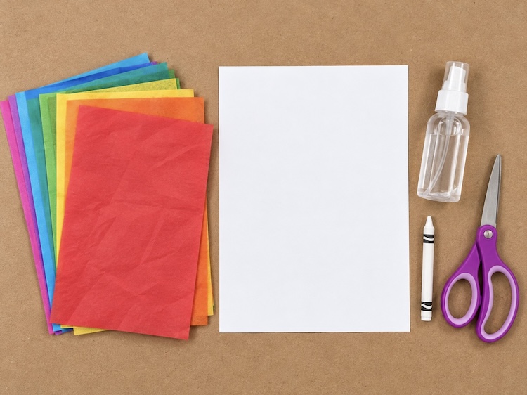 Bleeding tissue paper, cardstock, a white crayon, small spray bottle, and pair of scissors. The art supplies needed to make easy tissue paper art.