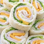 Close up view of turkey and cheese tortilla pinwheels on a plate ready to eat for a cold and yummy lunch.
