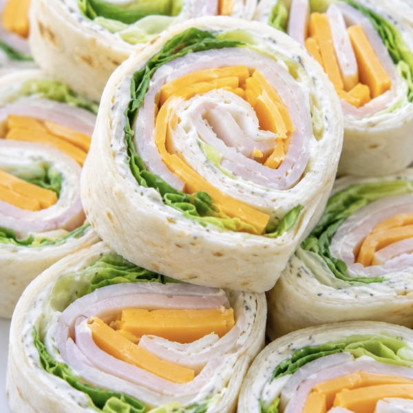 Close up view of turkey and cheese tortilla pinwheels on a plate ready to eat for a cold and yummy lunch.