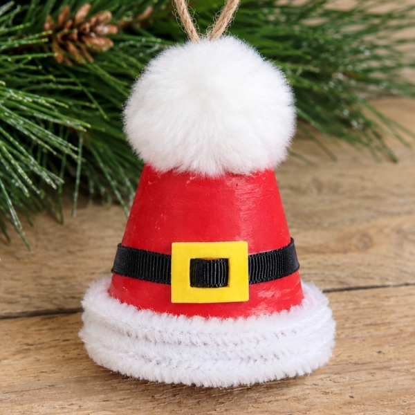 Easy Christmas craft for kids and adults! How to make a cute Santa hat ornaments for your Christmas tree or to give away as a handmade holiday gift. This easy project is made with with mini clay pots, white pipe cleaners, paint, and a fluffy pom-pom for the top.