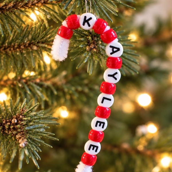 How to make the easiest DIY Christmas ornaments for kids using pipe cleaners and pony beads to make candy canes with their personalized name. No glue, no mess, and great for kids of all ages including preschoolers.