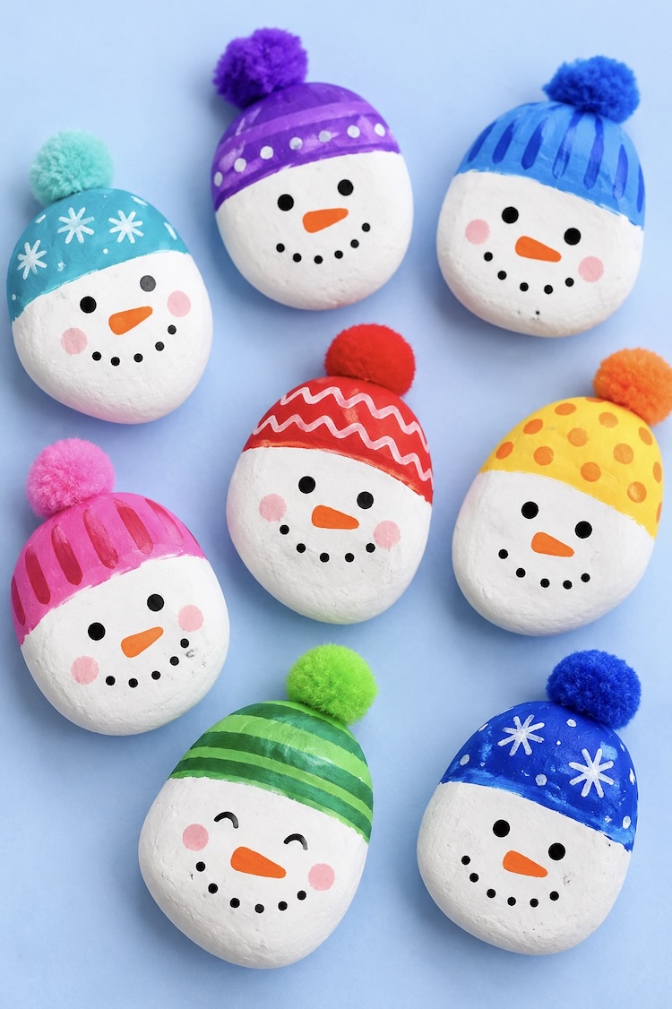 Easy craft tutorial: How to make cute little snowmen for Christmas using rocks, paint, and pom poms for the fuzzy little hat. This simple winter craft if great for kids of all ages and cheap to make with common supplies.