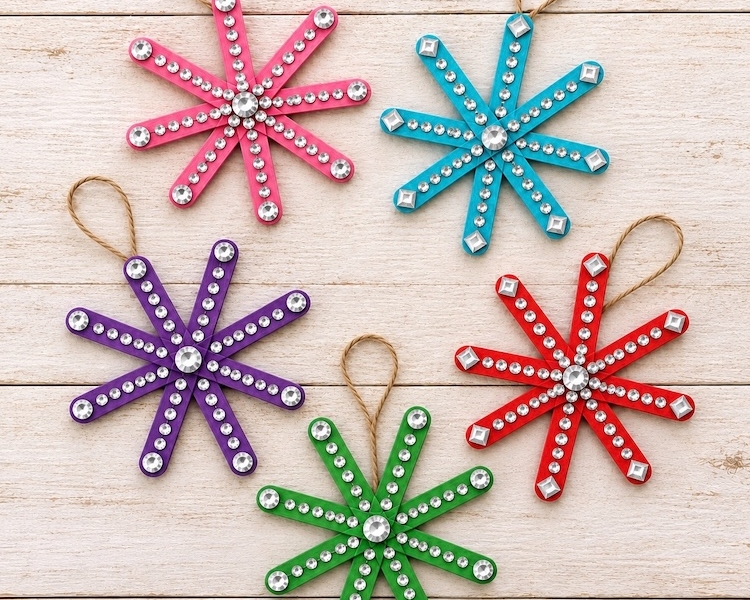 Popsicle stick snowflake ornaments are an easy, low mess Christmas craft for kids to make at home. Decorate them with rhinestone stickers and hang them on your Christmas tree for the holidays. So simple but really pretty!