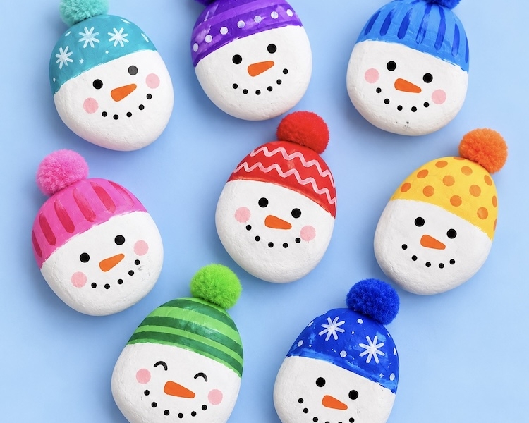 Cute DIY Snowman Rocks made with just paint, acrylic or paint markers, and a fuzzy pom-pom for its adorable hat. An easy and cheap holiday craft for kids to make!