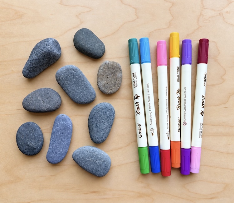 Small smooth rocks and a variety of colorful acrylic paint markers.