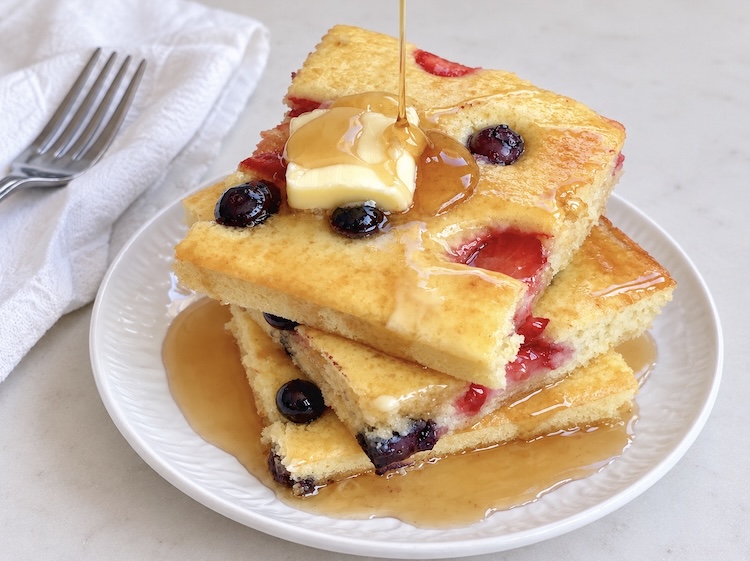 Square cut pancakes on a plate ready to eat! A fun and easy breakfast idea for a crowd. How to make pancakes in the oven on a sheet pan.